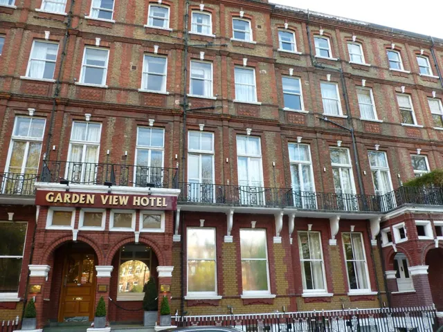 The brick front of the Garden View Hotel, showing a multi-storey Victorian facade, an arched entrance with a wooden door, and wrought-iron balconies.