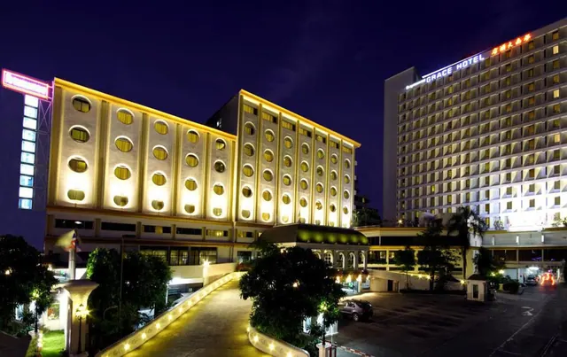 Night exterior of the Grace Hotel with illuminated facades, a lit driveway, and a parked car in the forecourt.
