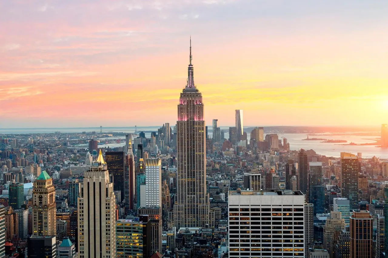 Aerial view of the Manhattan skyline at sunset with the Empire State Building rising in the centre.