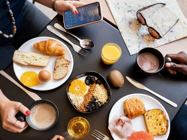 A breakfast table holds pastries, bread, fruit, cereal, juice, coffee and tea beside a map of Paris.
