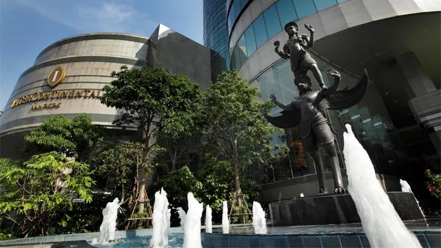 The exterior of the InterContinental Bangkok hotel, with a water fountain and a large bronze statue in the foreground.