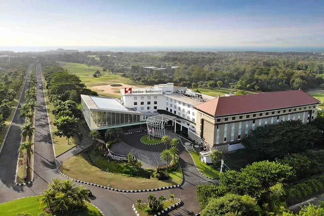 Aerial view of the Swiss-Belresort hotel building with its curved driveway, surrounding gardens, golf course and tree-lined roads.