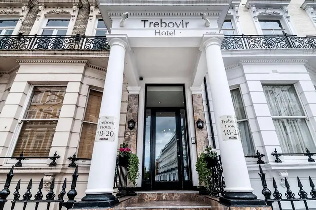 The Trebovir Hotel entrance has white columns, a canopy with the hotel name, black glass doors, and iron balcony railings on a white terraced facade.